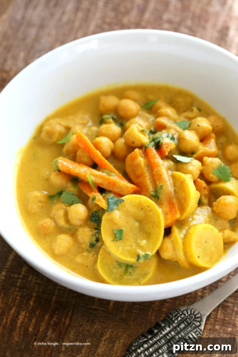One-Pot Turmeric Peanut Butter Chickpea Curry 3 Close-up of golden Chickpeas in Turmeric Peanut Butter Curry, showcasing the rich sauce and tender summer vegetables.