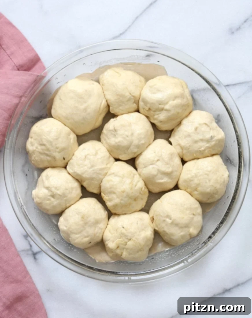 Cheesy Pizza Monkey Bread 6 Individual pizza dough balls arranged in a deep pie pan, having risen for 10 minutes, awaiting the delicious cashew cream and pizza sauce for Vegan Cheesy Pull Apart Pizza Bread.
