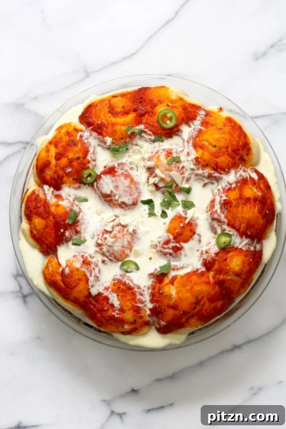 Cheesy Pizza Monkey Bread 8 Pizza dough rolls layered with more cashew cream, fresh basil, and sliced jalapenos, ready for the final bake to become a savory Vegan Pull Apart Pizza Bread.