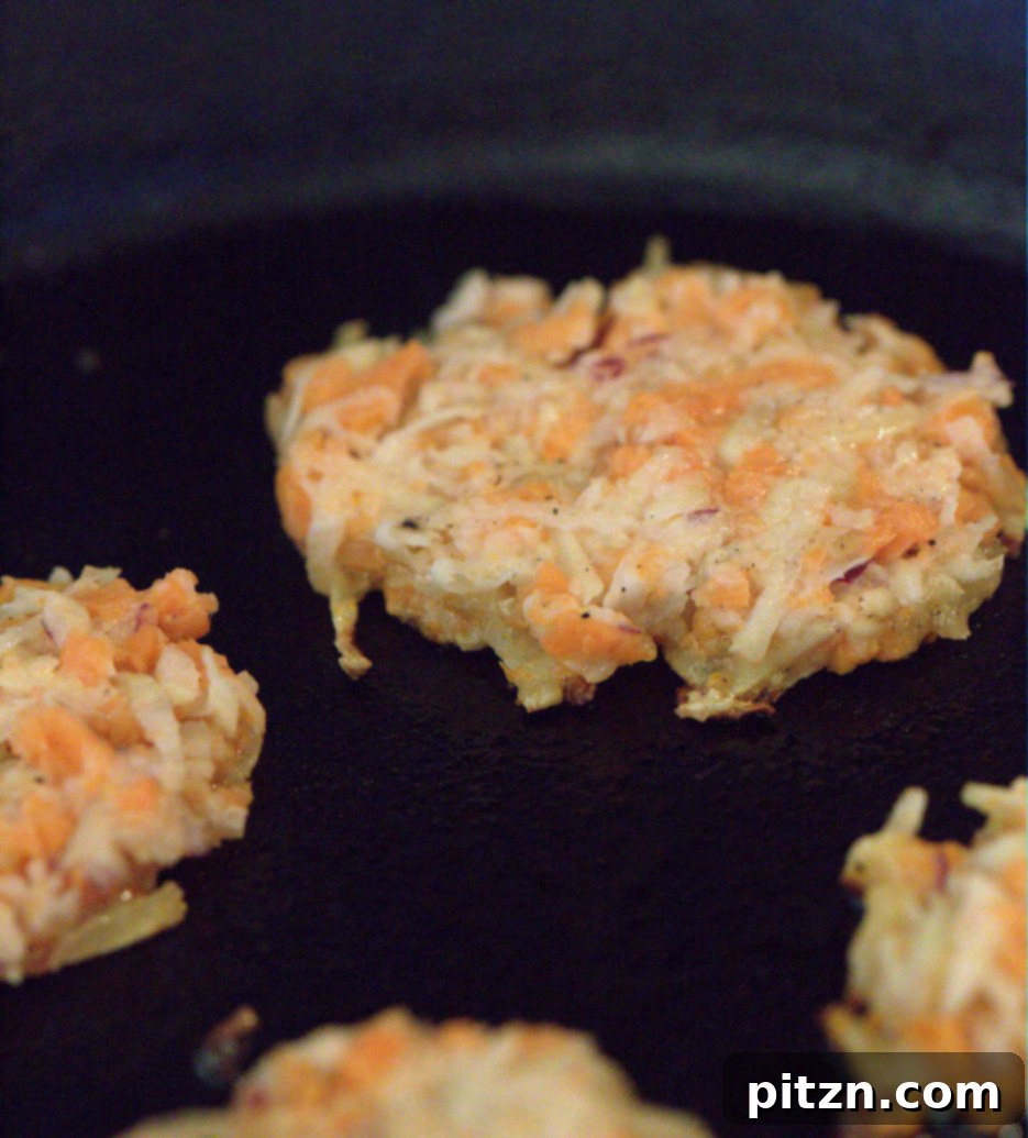 Close-up of golden brown vegan sweet potato latkes, pan-fried to perfection