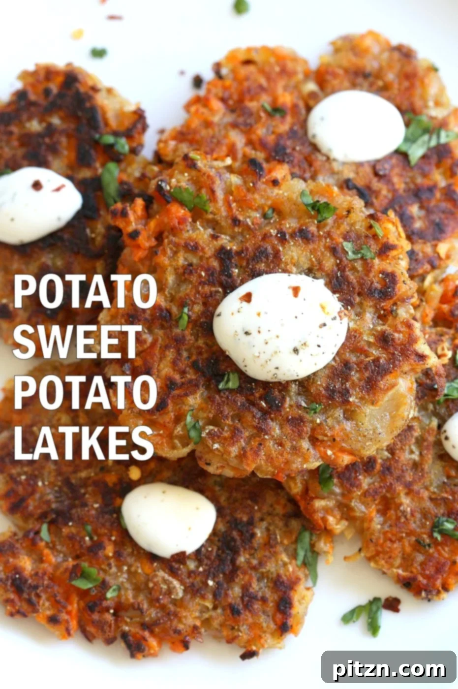 Freshly cooked vegan potato and sweet potato latkes garnished with herbs