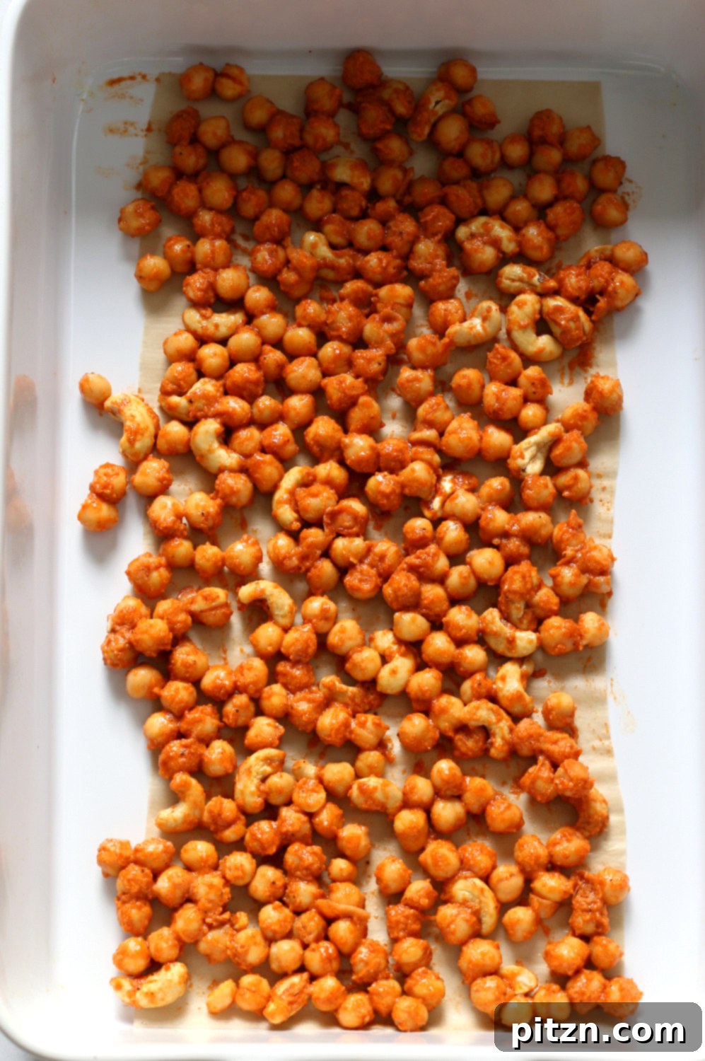 Spicy Sriracha Chickpea Cashew Spinach Power Bowl with Golden Curry 4 Sriracha coated chickpeas in a baking dish before roasting for the bowl