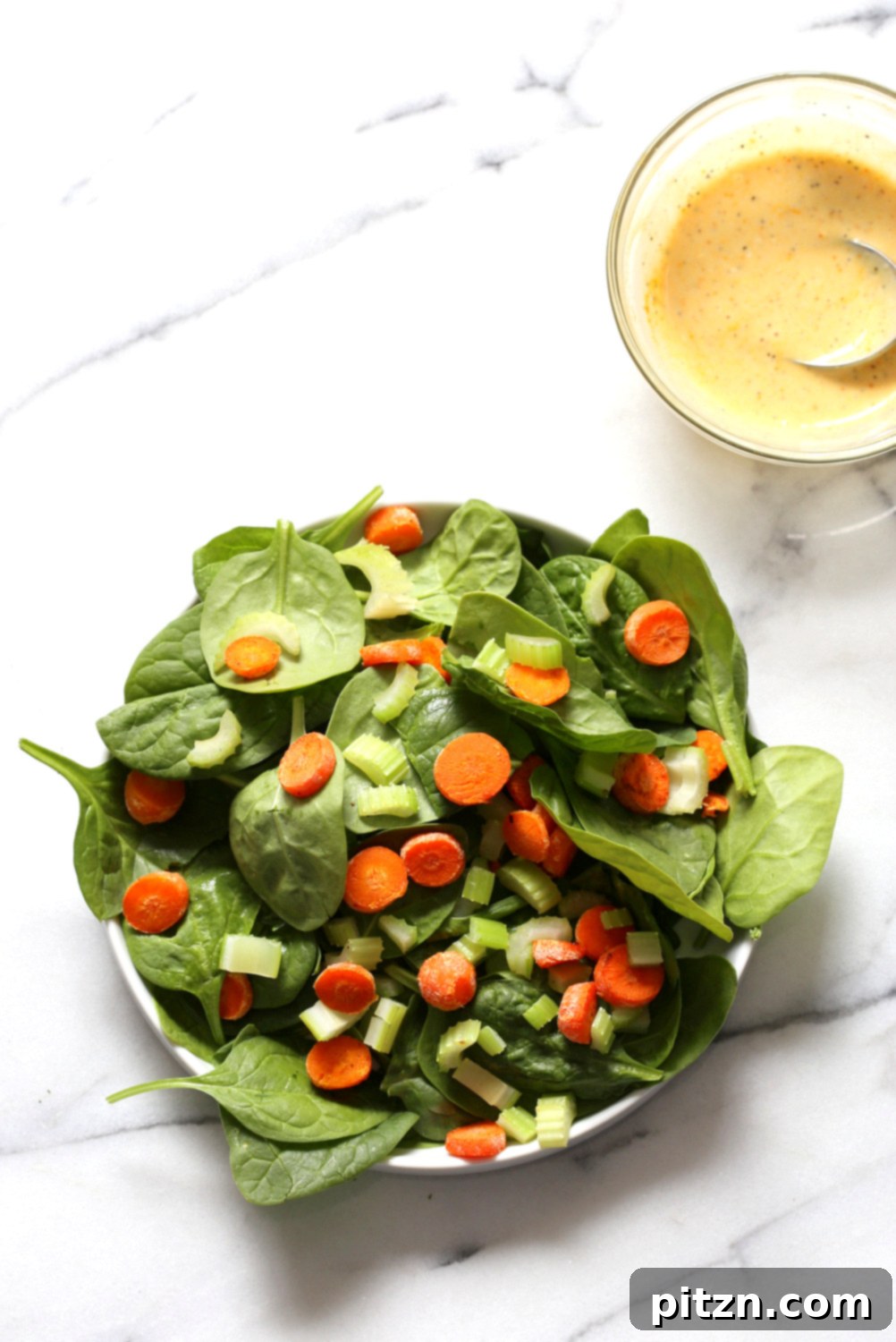Spicy Sriracha Chickpea Cashew Spinach Power Bowl with Golden Curry 5 Assembling a Sriracha Chickpea Spinach Bowl on a marble surface