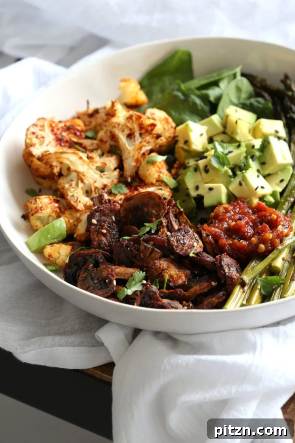 Close-up of roasted cauliflower, mushrooms, and asparagus coated in Korean Gochugaru blend. Vegan and Gluten-free.