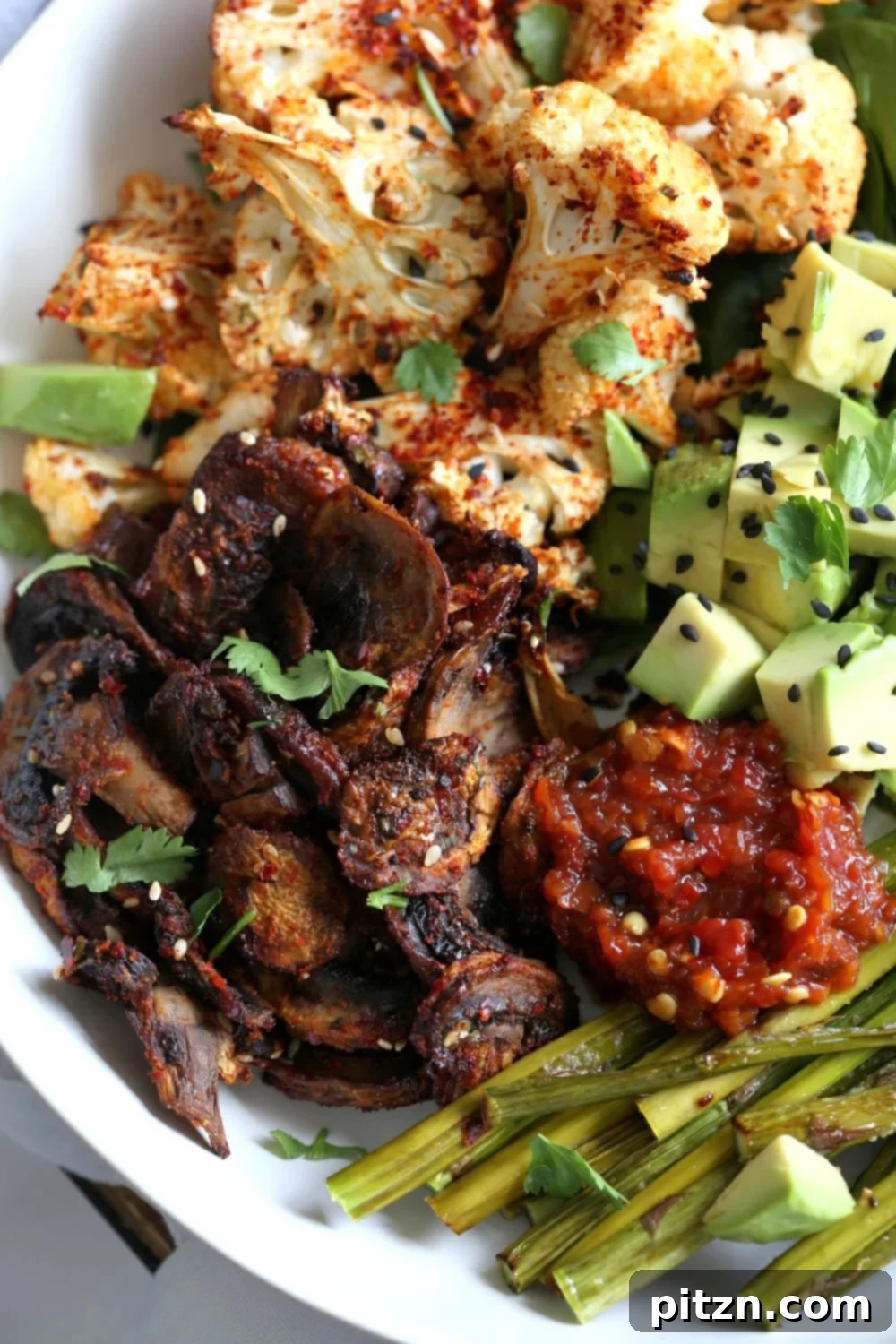 Colorful Bulgogi Roasted Spring Veggie Bowl assembled with fresh greens, avocado, and chili sauce. Perfect for a healthy meal.