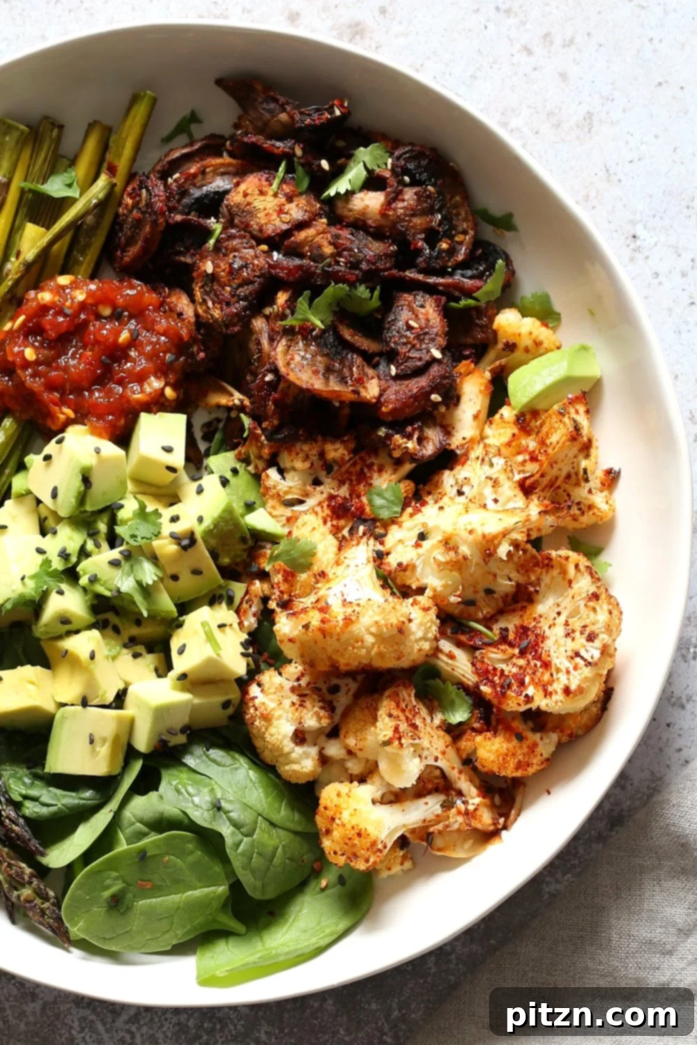 Close-up of the delicious Bulgogi Roasted Spring Veggie Bowl, garnished with sesame seeds and scallions.
