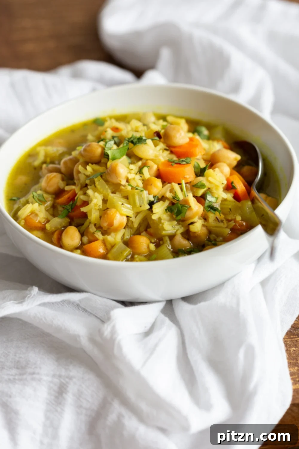 Vegan Chickpea Rice Soup in a white bowl over white cotton napkin
