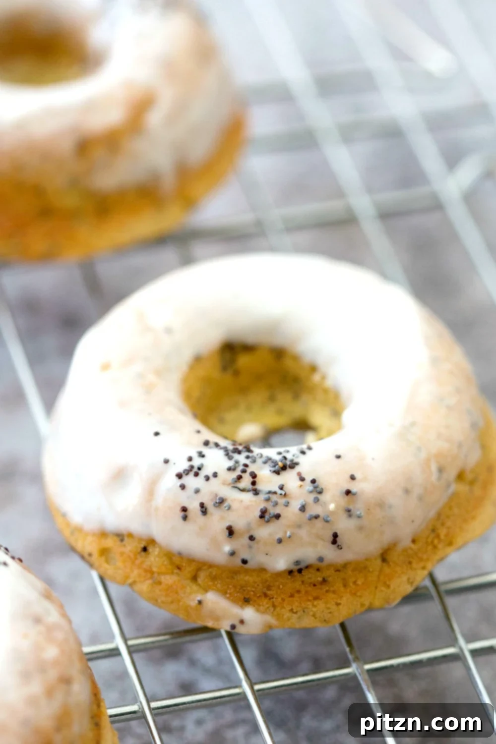Zesty Vegan Lemon Poppy Seed Delights 5 Several Vegan Lemon Poppy Seed Donuts arranged beautifully on a cooling rack, some with a delicate glaze.