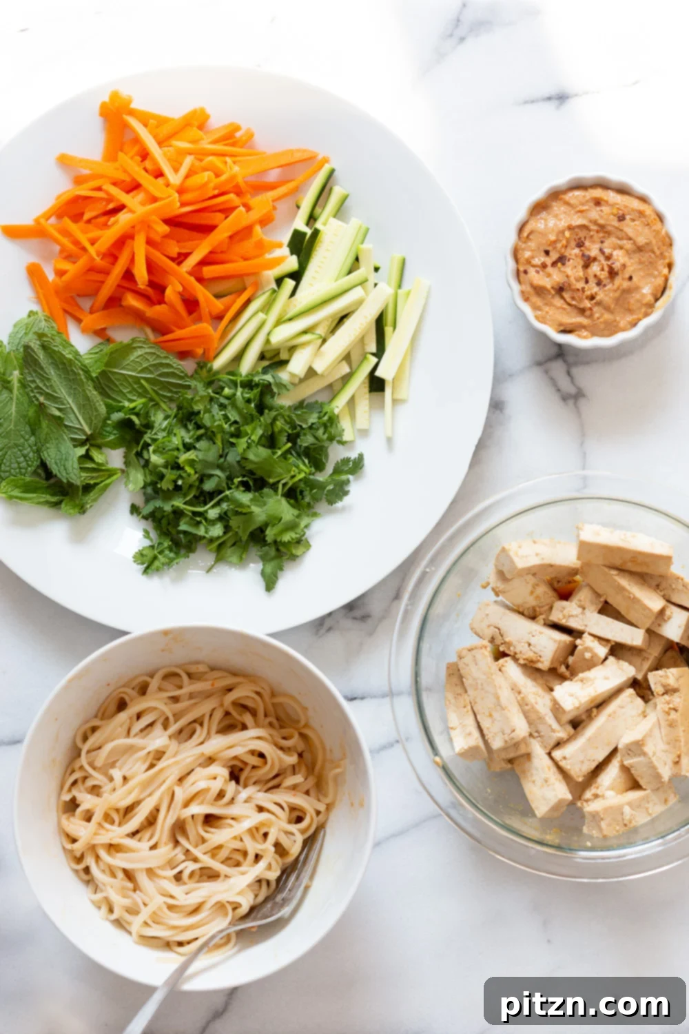 Various colorful ingredients for vegan fresh spring rolls neatly arranged in white bowls.