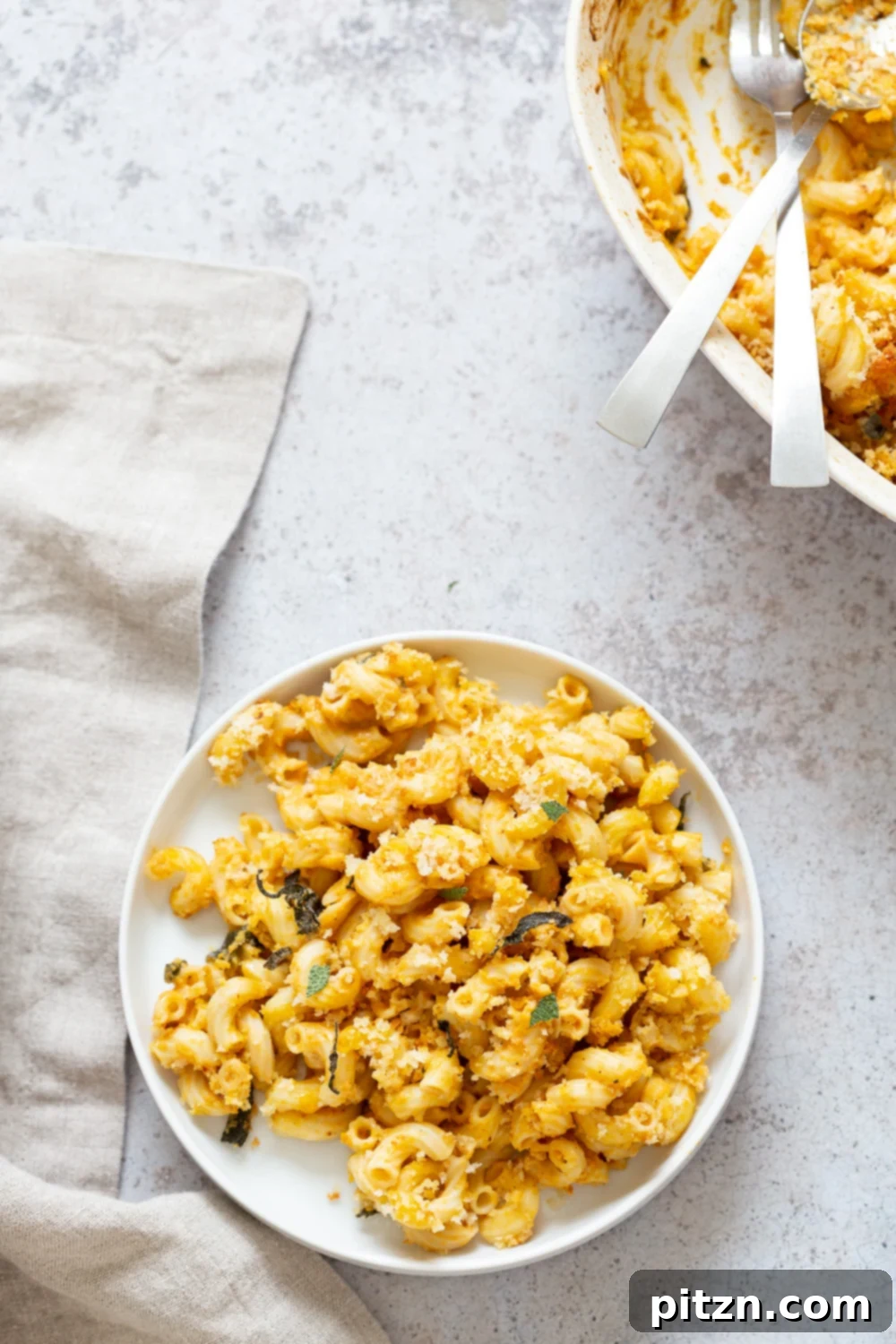 Golden Harvest Vegan Mac and Cheese Bake 3 Overhead view of a baking dish filled with golden-brown Vegan Pumpkin Mac and Cheese, featuring a rich pumpkin sauce.
