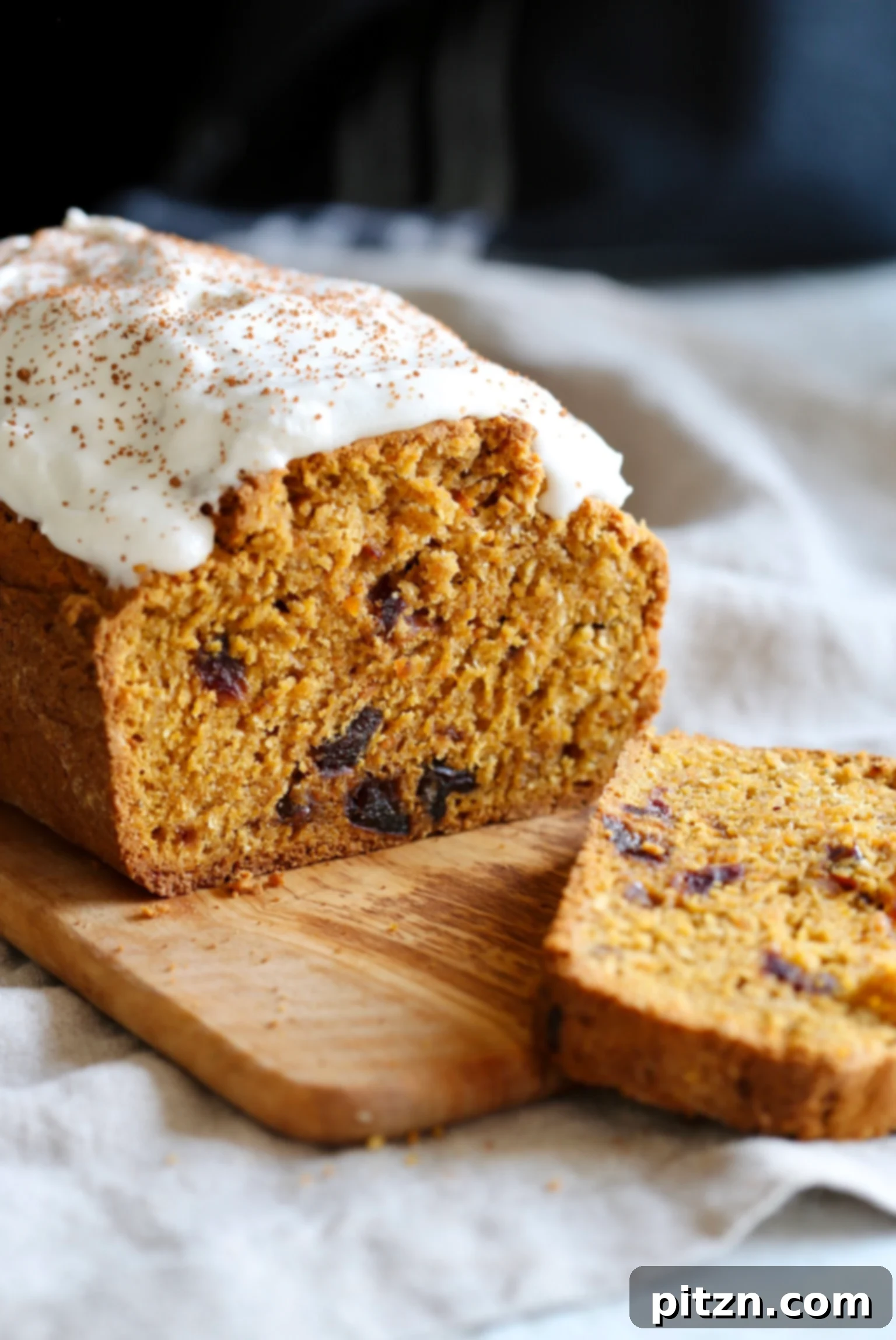 A sliced loaf of vegan pumpkin carrot bread on a wooden cutting board, showcasing its delightful interior and inviting texture.