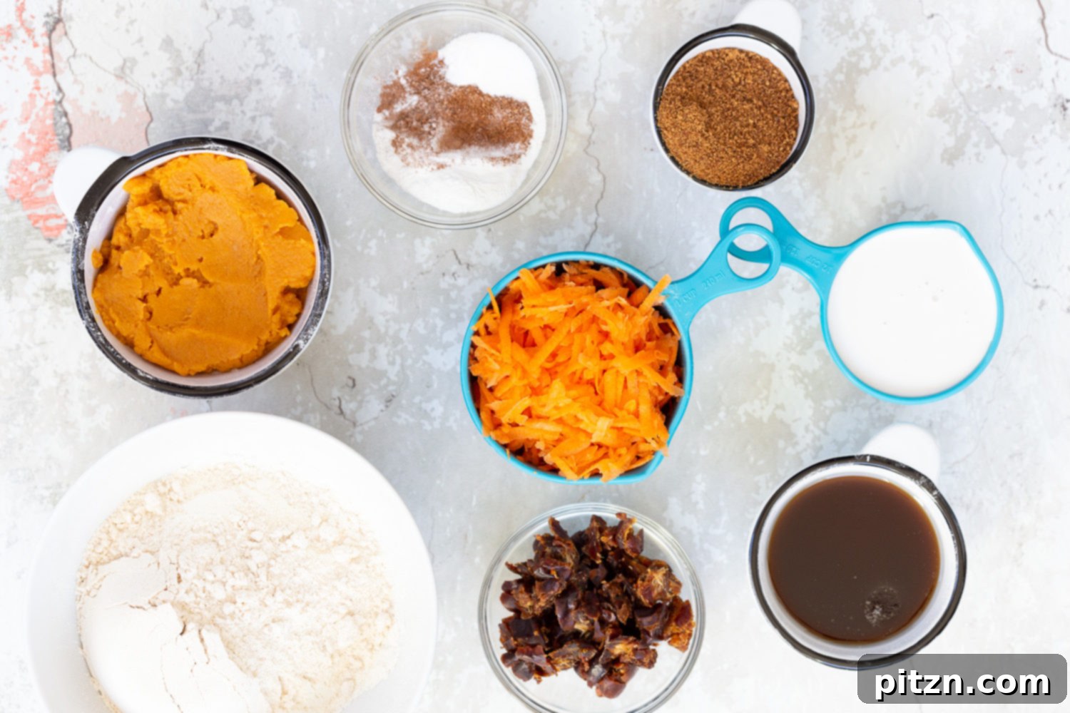 Ingredients for vegan carrot pumpkin bread laid out on a work surface, ready for mixing.