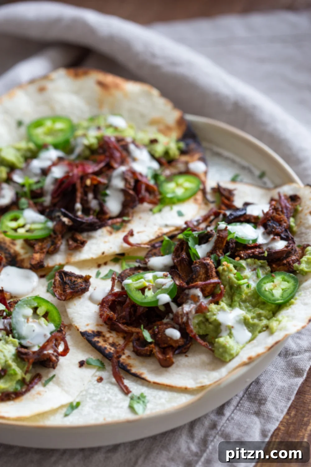 Close-up of crispy and tender Vegan Carnitas made with mushrooms, prepared with a spicy, smoky, and zesty marinade. Ideal for plant-based tacos, wraps, and burritos, showcasing the rich texture and vibrant colors.