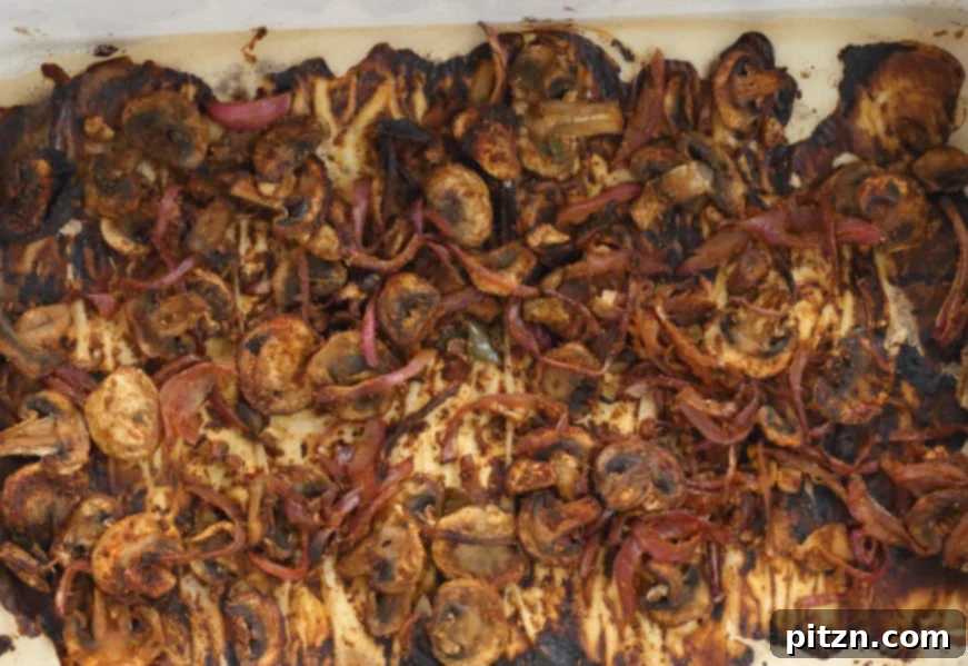 Baked Vegan Carnitas, featuring perfectly browned and caramelized mushrooms and onions, fresh out of the oven, ready to be served.