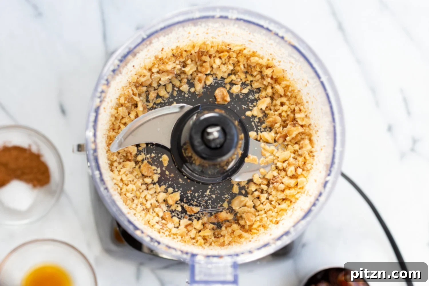 Walnuts being processed in a food processor, ready to be combined with other ingredients for Vegan Carrot Cake Bites.
