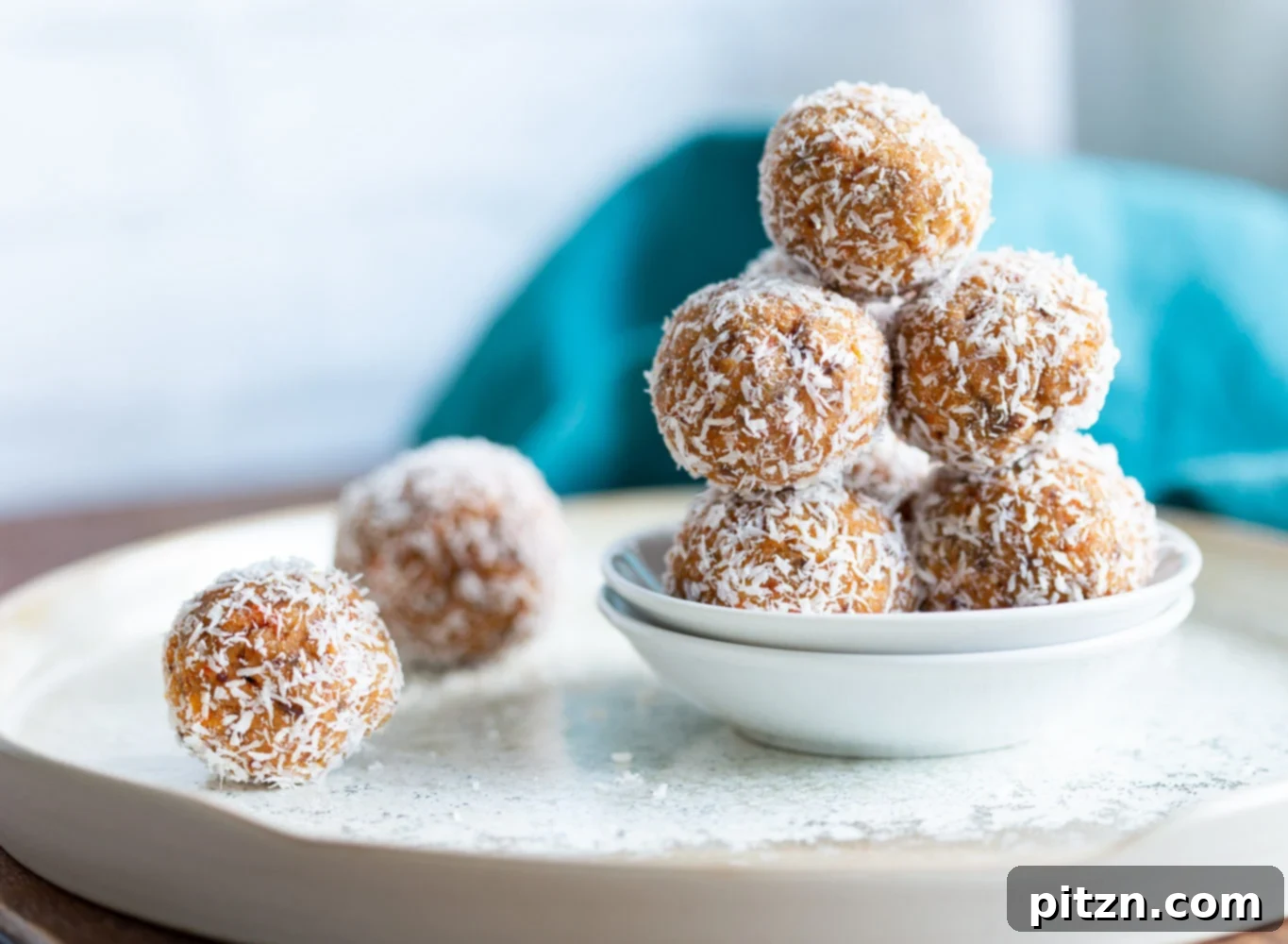 A selection of Easy Vegan Carrot Cake Bites, some coated in coconut and others with a glaze, presented artfully for a healthy snack.