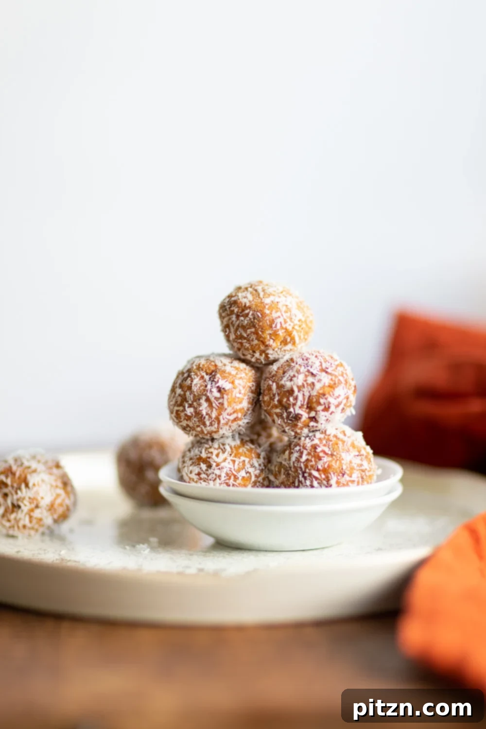 Beautifully arranged Vegan Carrot Cake Bites with shredded coconut and a light drizzle, showcasing their irresistible texture and perfect for sharing.
