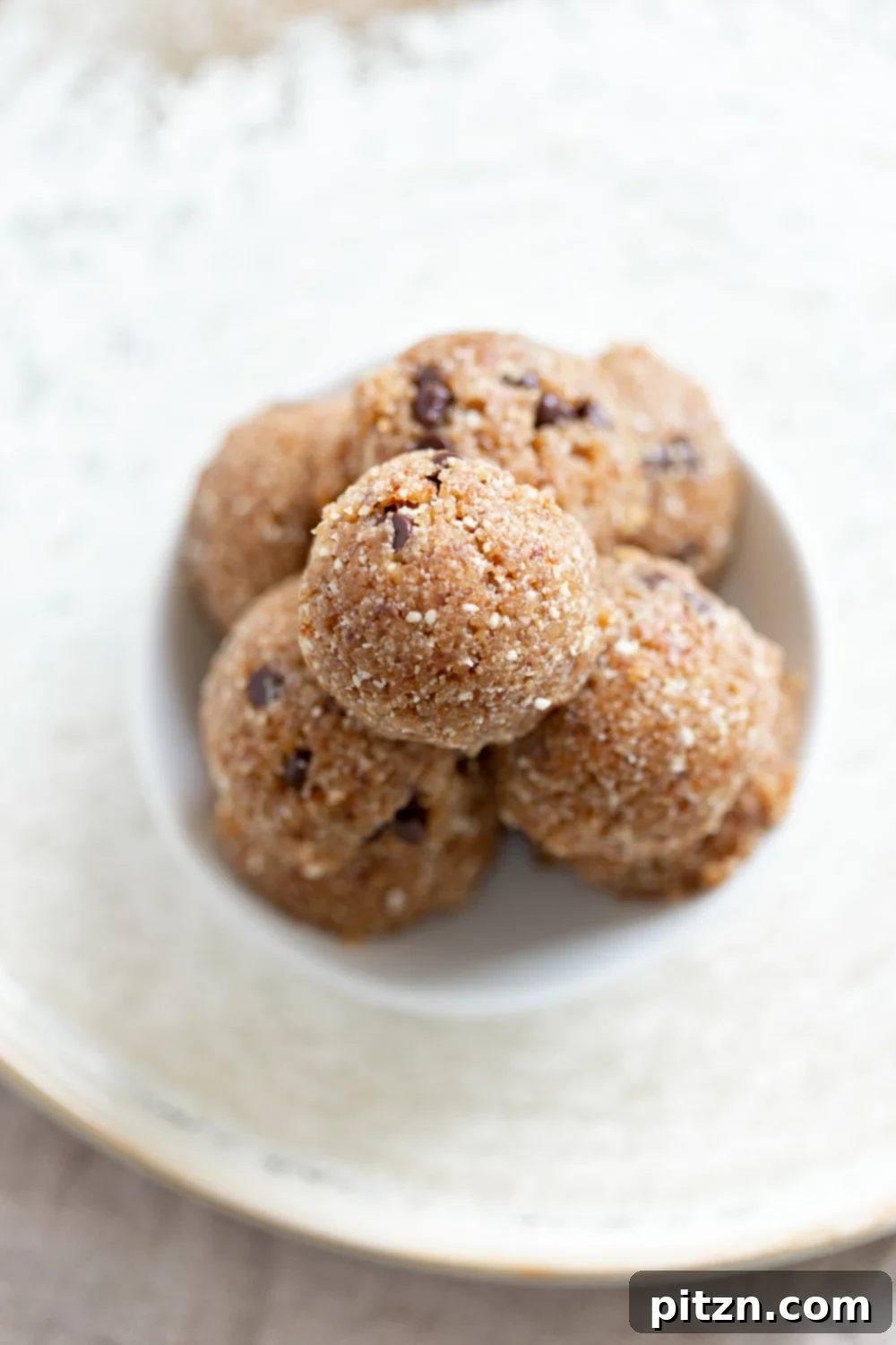 No-Bake Vegan Dough Delights 2 Our Vegan Cookie Dough Bites on a white plate, showcasing their inviting texture and chocolate chips.