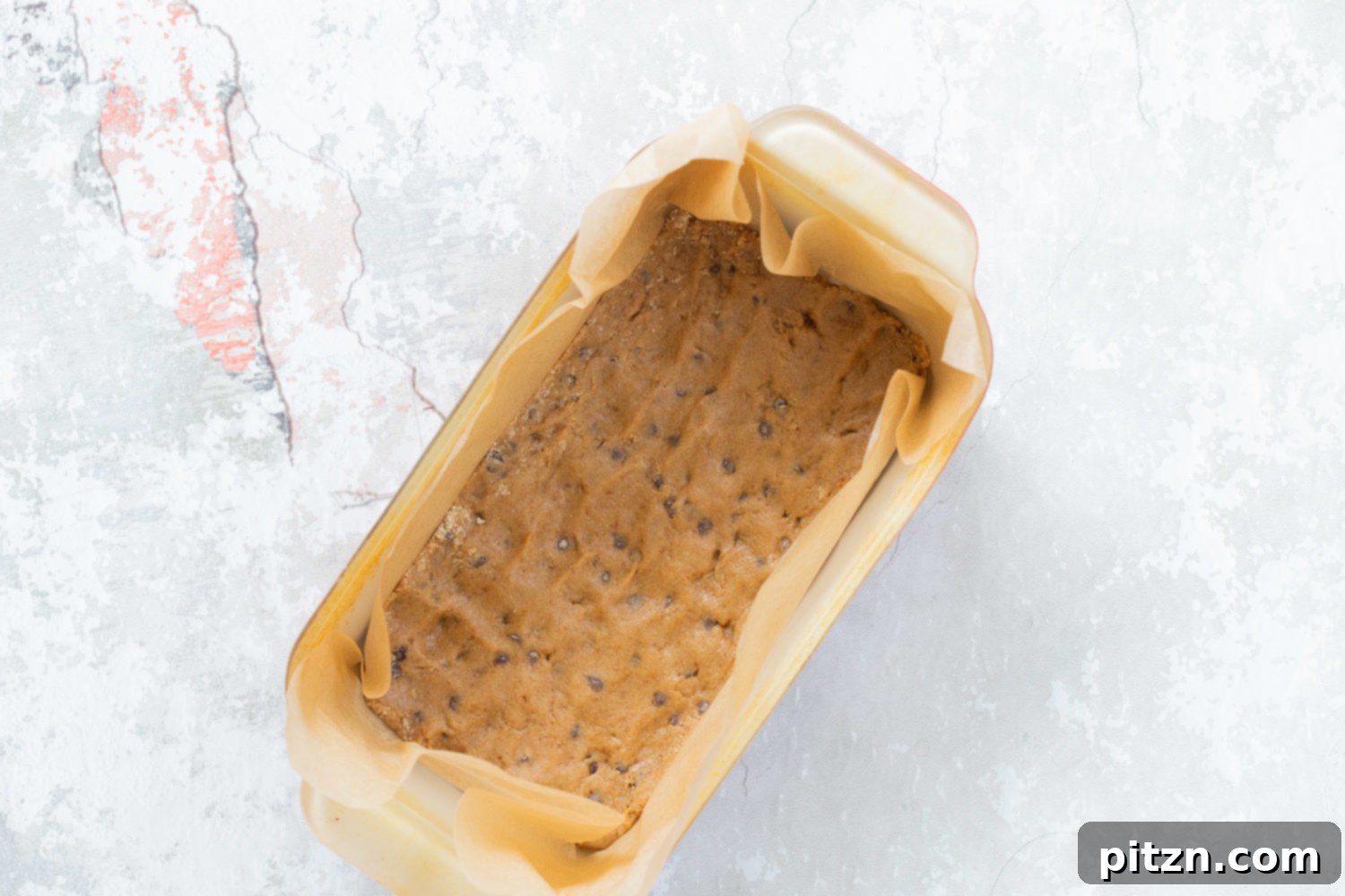 First cookie dough layer pressed into a baking pan for our Vegan Cookie Dough Ice Cream Sandwiches
