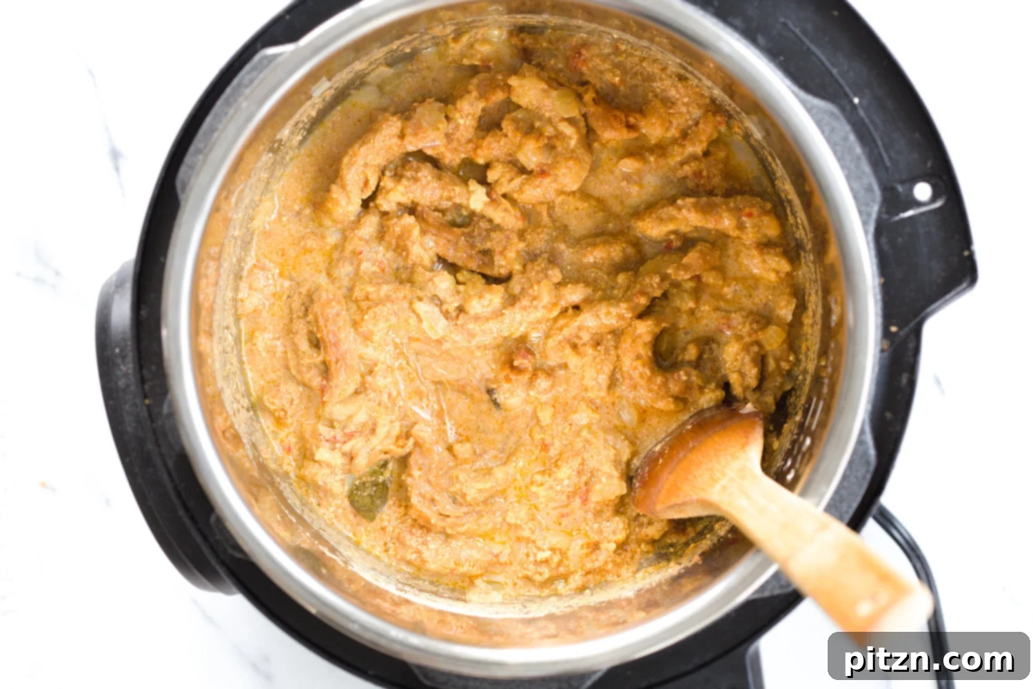 vegan creamy fenugreek curry with soy curls being stirred in an instant pot