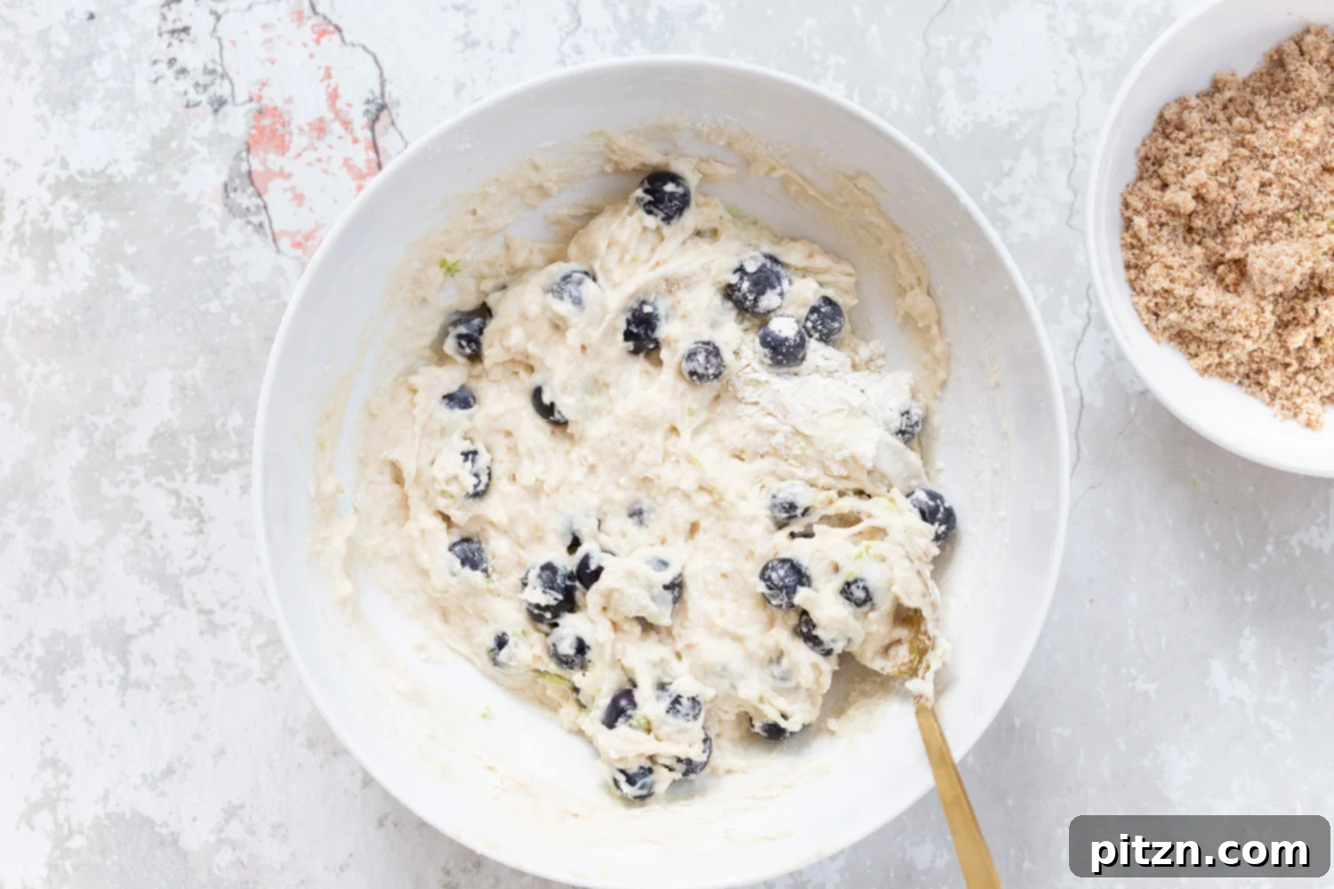 Batter for our Vegan Blueberry Muffins in a white bowl