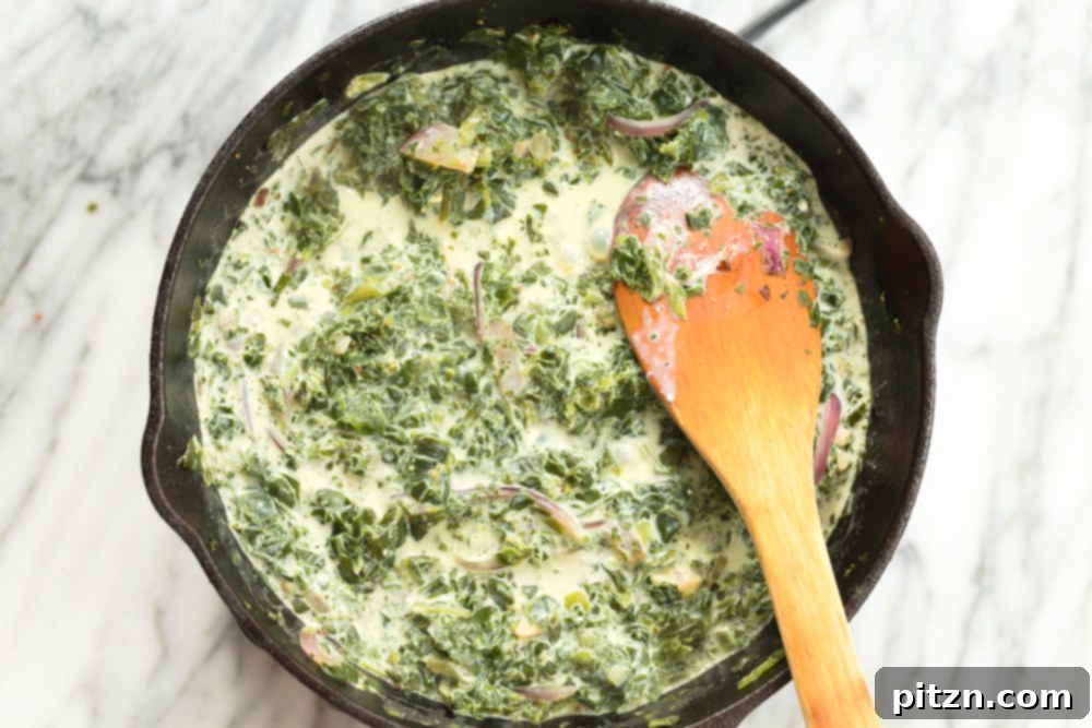Creamy non dairy milk added to spinach in cast itron skillet