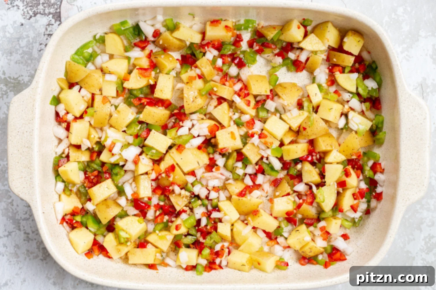 Crispy golden breakfast potatoes baking in a white ceramic dish, ready to be served