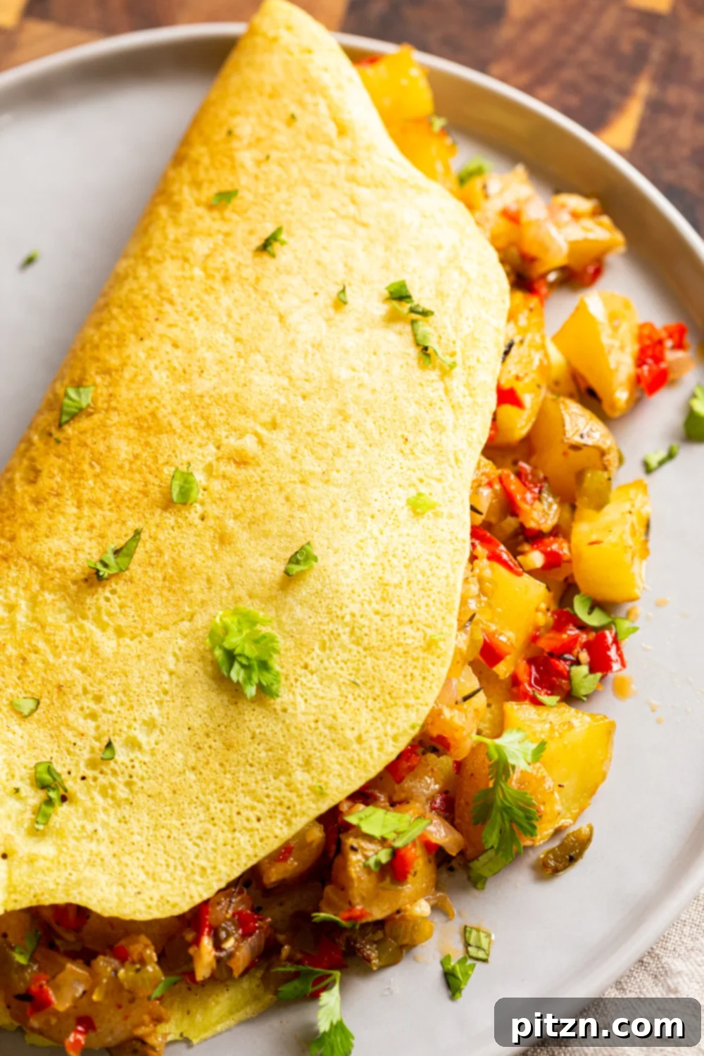 A beautifully plated Vegan Omelet with a generous serving of crispy Breakfast Potatoes, ready to enjoy