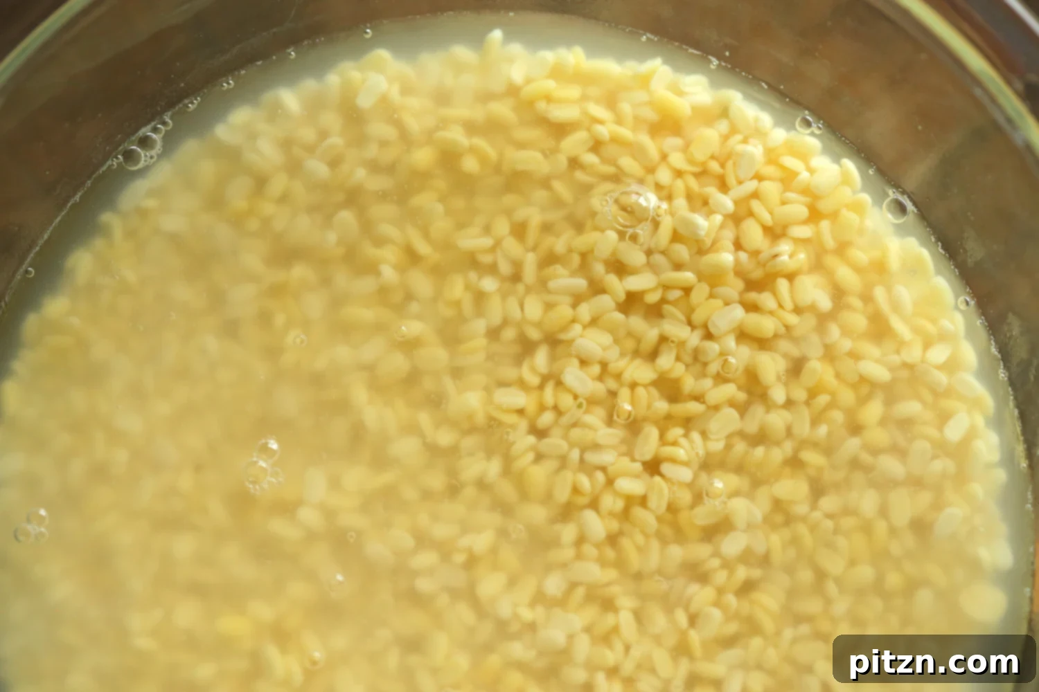Moong Dal soaking in a clear glass bowl, preparing for the vegan omelet batter