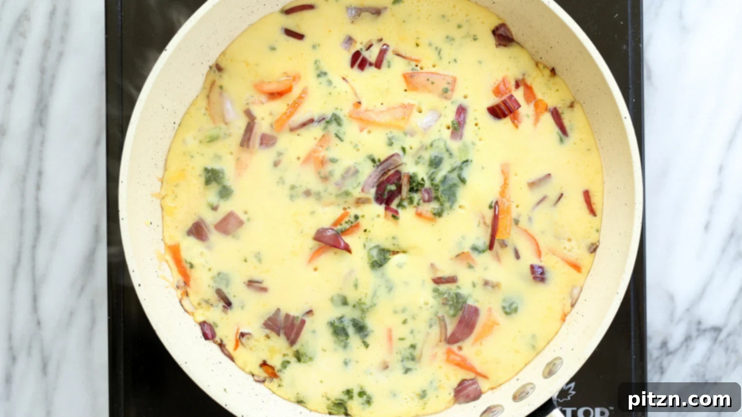A vibrant, veggie-filled Vegan Omelet, showcasing colorful vegetables, cooked to perfection in a white skillet
