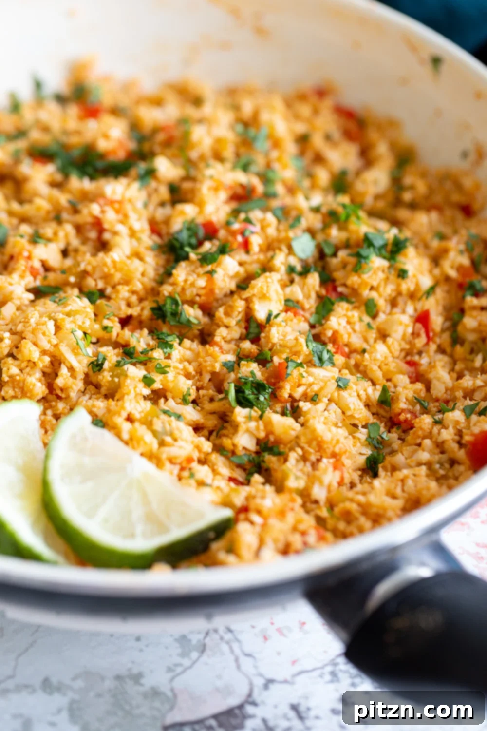 Spanish Cauliflower Rice side view of healthy vegan Spanish cauliflower rice in a pan