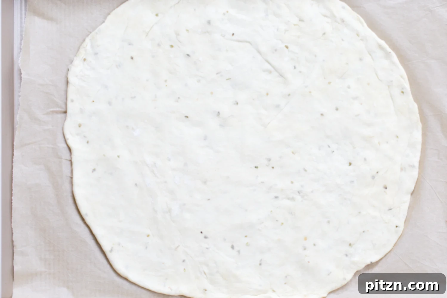 yeast free pizza dough rolled out pizza dough on parchment paper