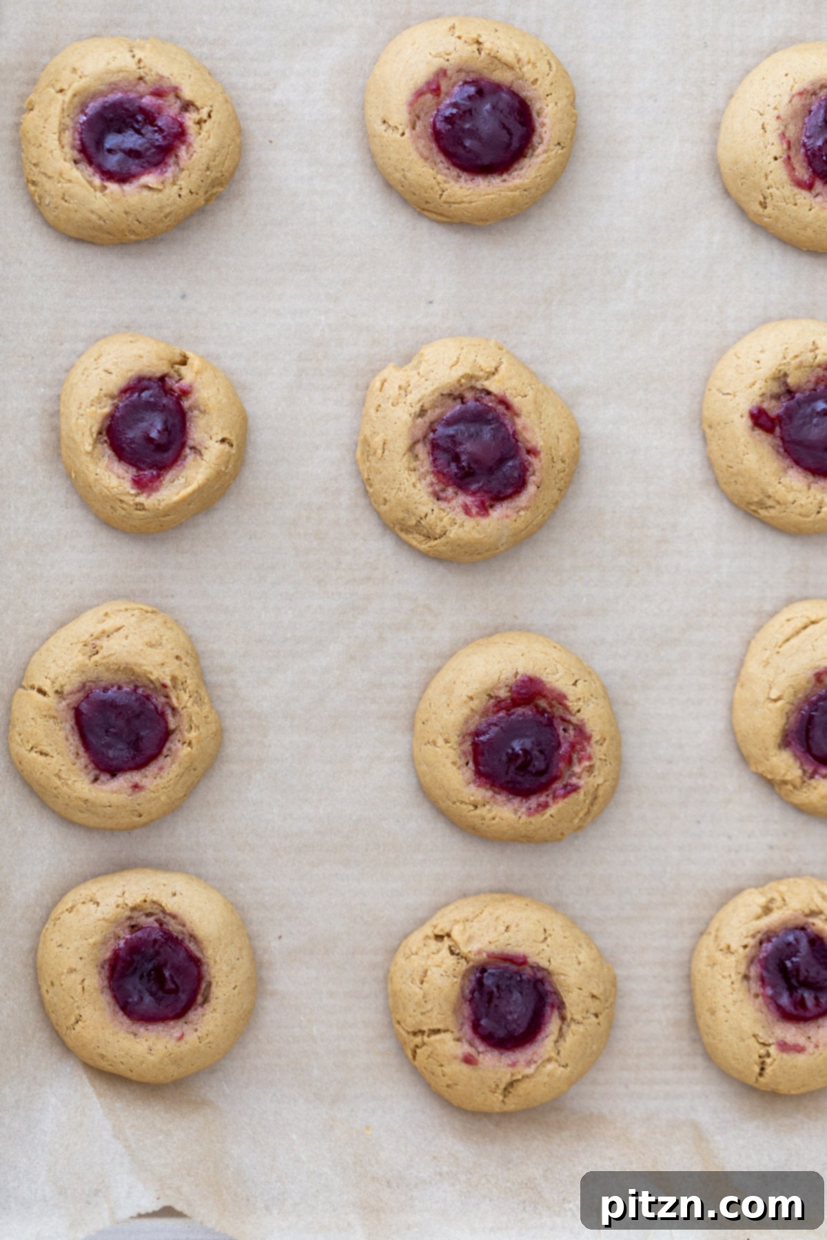 overhead shot of a cookie tray with freshly baked pb&j thumbprint cookies