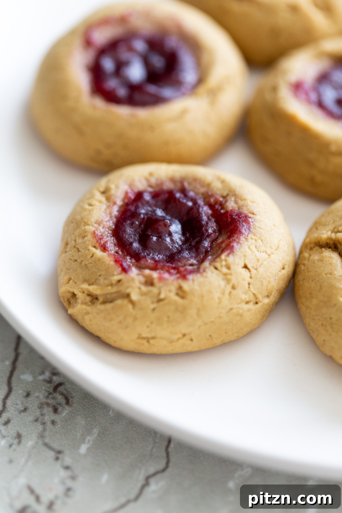 side view of a plate with vegan pb & j thumbprint cookies