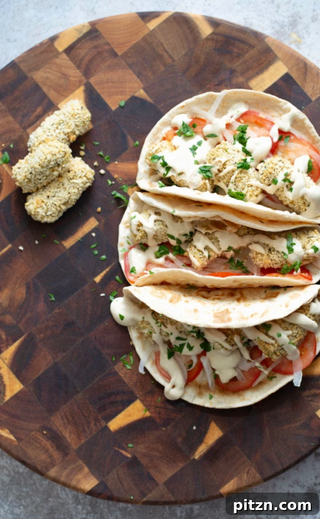 three vegan wraps filled with vegan chickpea quinoa croquettes and drizzled with tahini sauce