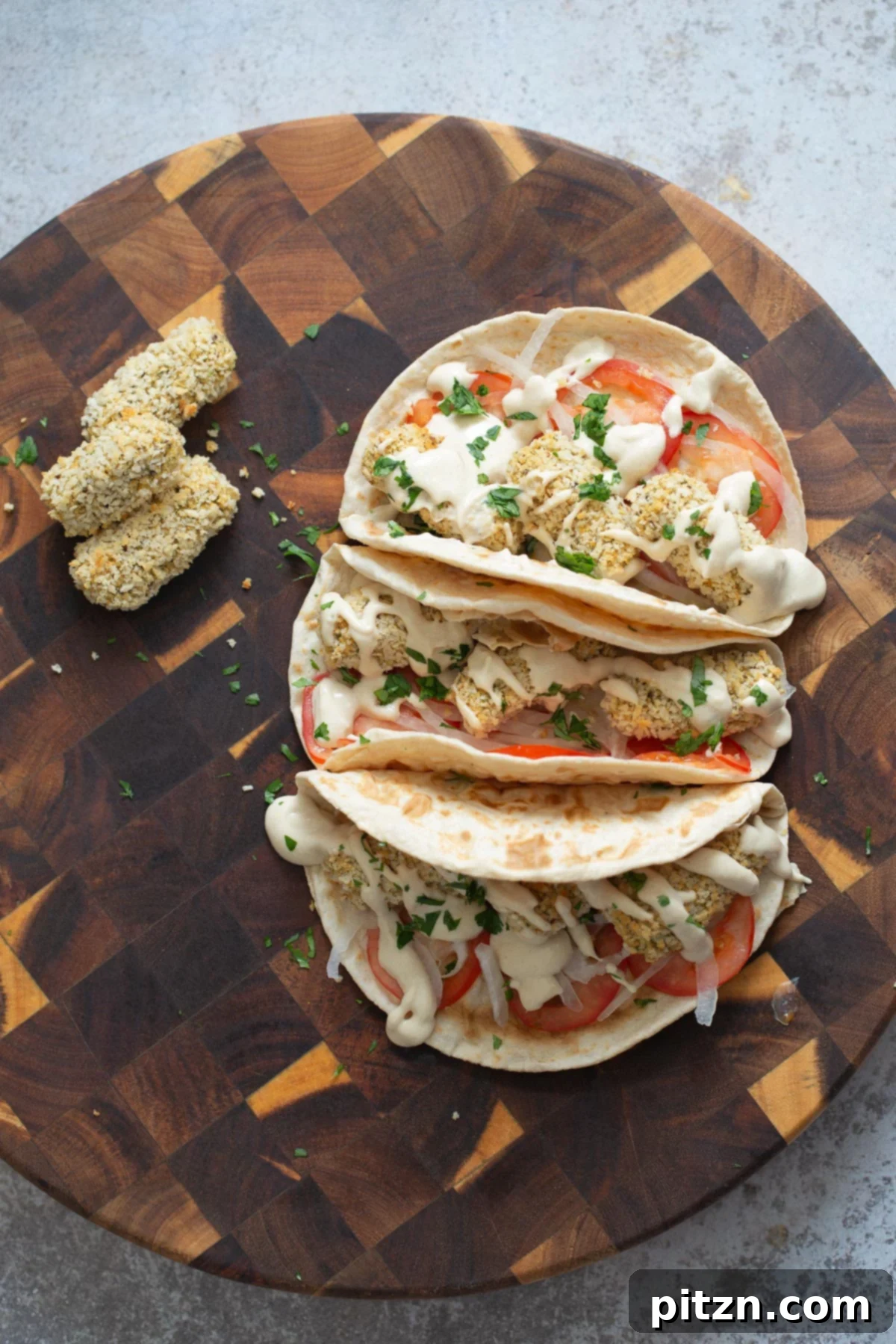 three wraps filled with vegan chickpea quinoa croquettes on a chopping board