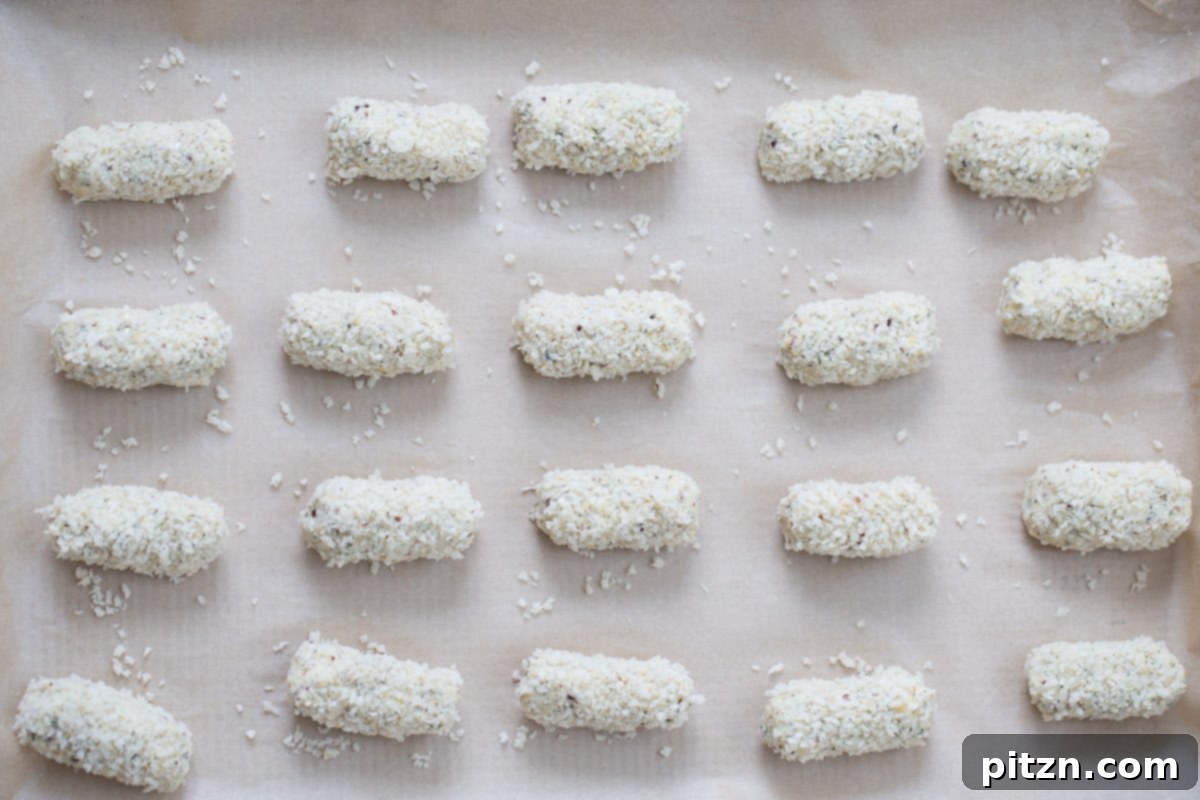 unbaked vegan quinoa chickpea croquettes rolled in breadcrumbs on a baking sheet 