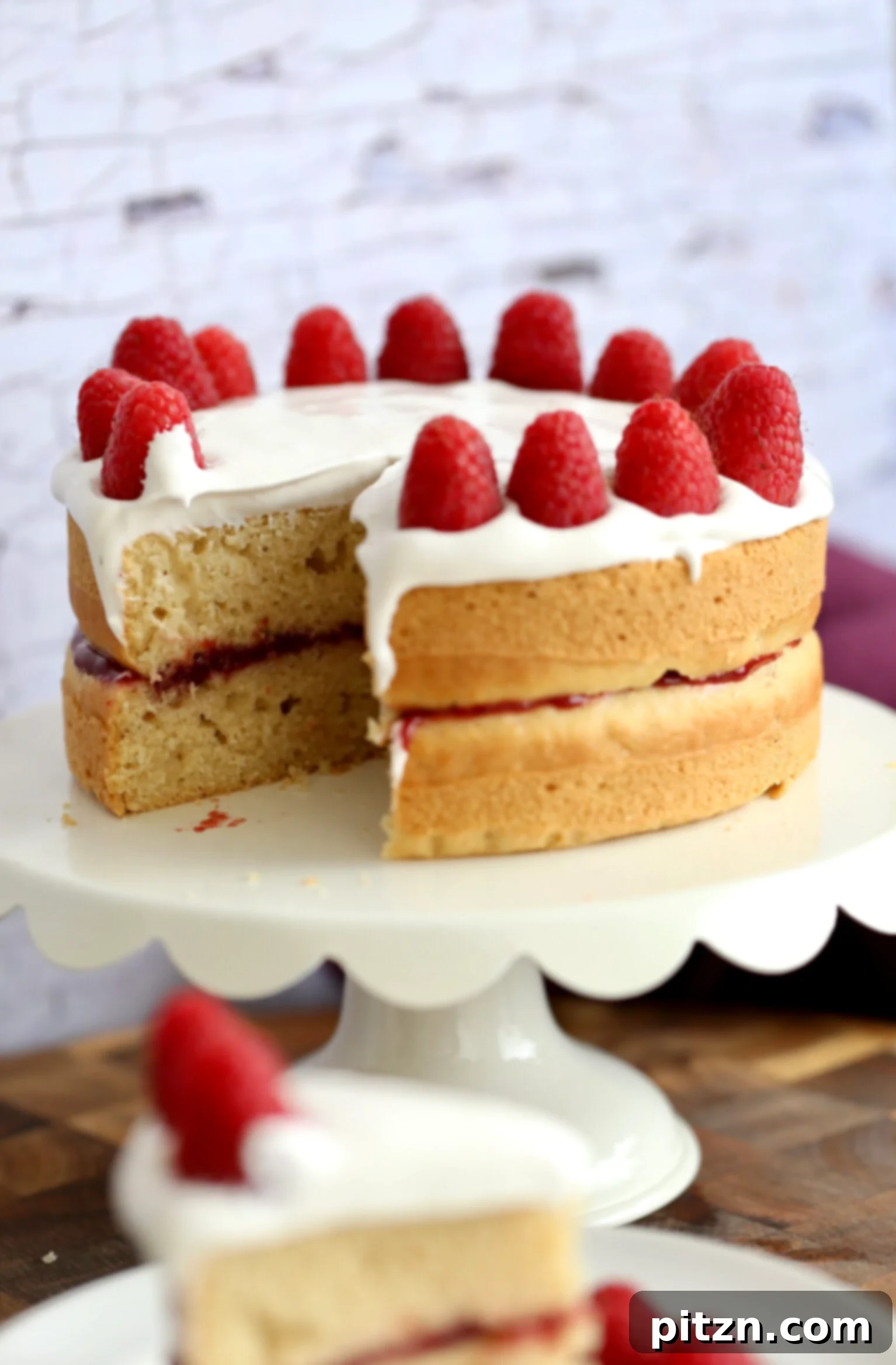A beautifully presented whole vegan white cake, frosted and adorned, ready to be sliced and served.