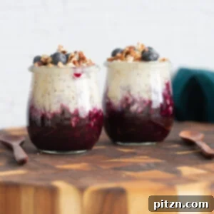 A close-up of a jar of Vegan Blueberry Muffin Overnight Oats, topped with fresh blueberries.
