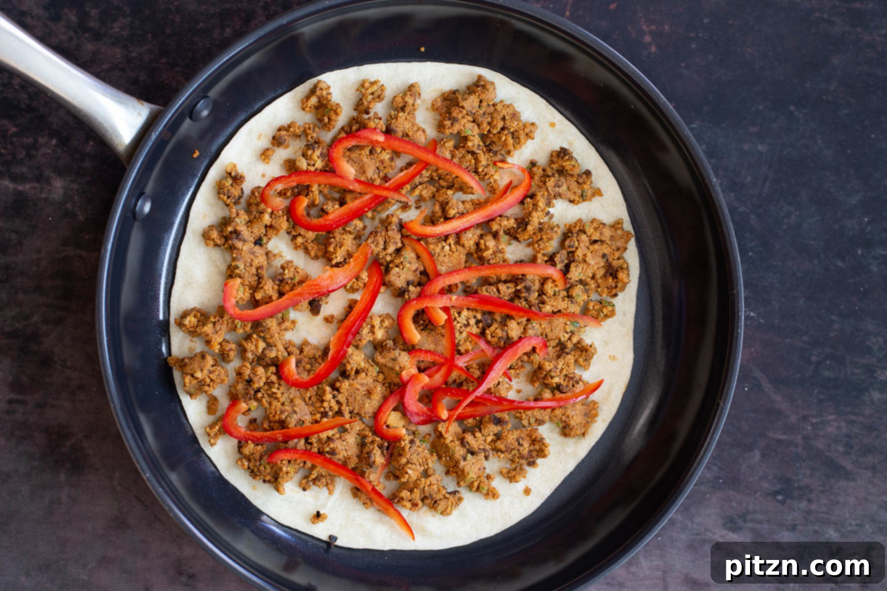 vegan walnut taco meat quesadilla being assembled in black skillet