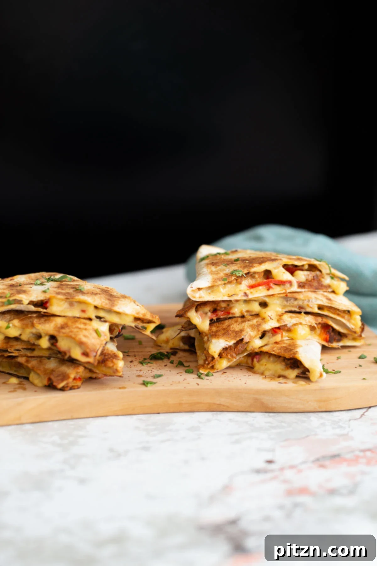 side view of vegan quesadillas filled with vegan walnut taco meat, bell pepper and melted cheese