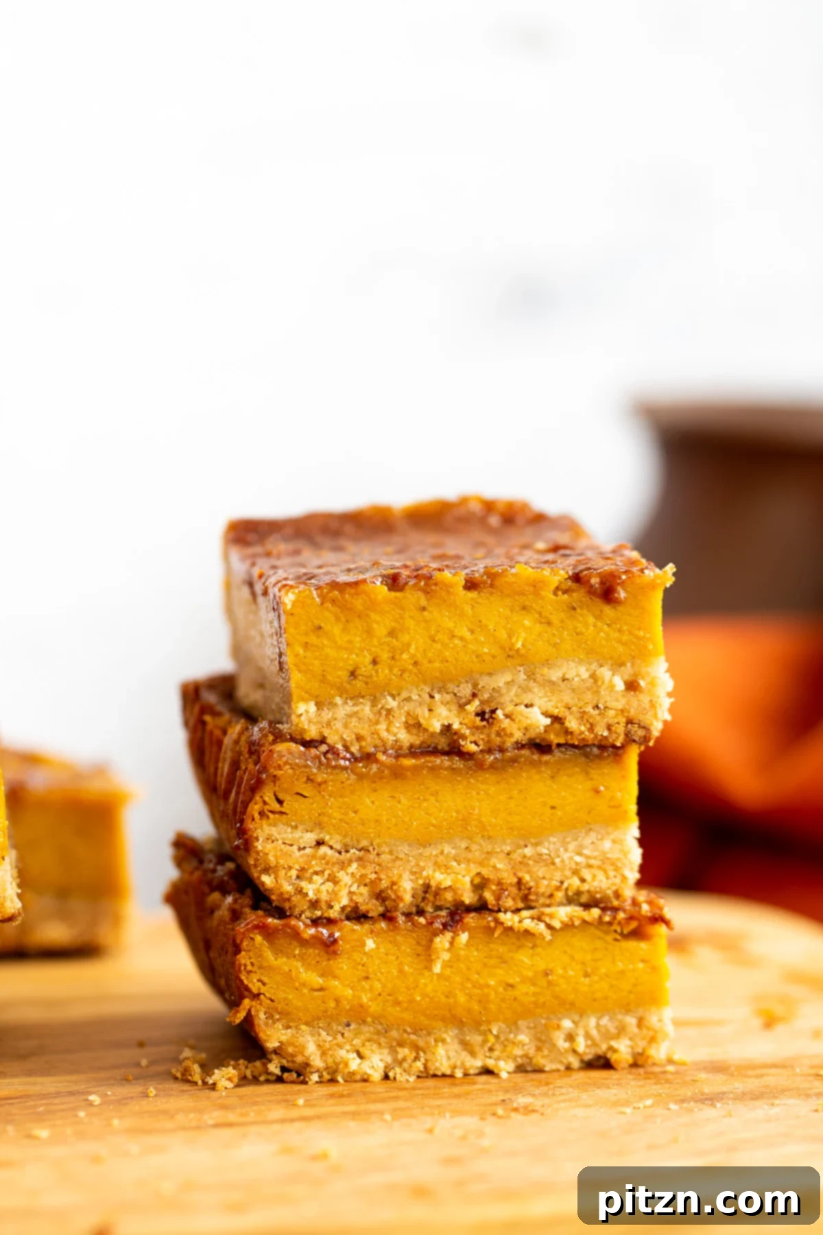 stacked vegan pumpkin pie bars on a wooden board