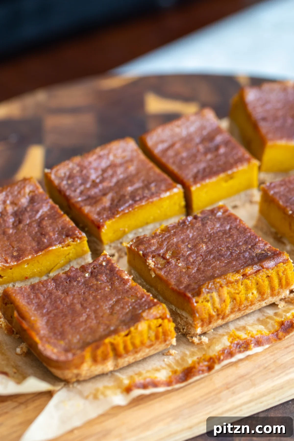 sliced vegan pumpkin pie bars arranged on a piece of parchment paper