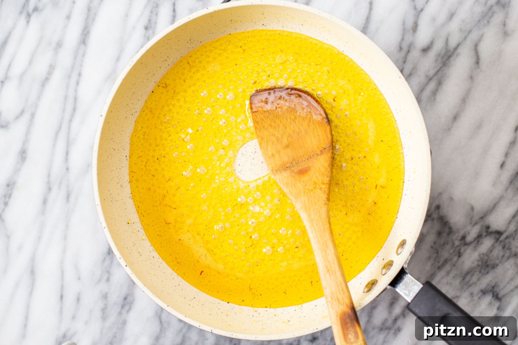 Rich Plant-Based Almond Burfi 4 Saffron, vegan butter, water, and sugar gently melting together in a non-stick saucepan, forming the aromatic base for almond burfi.