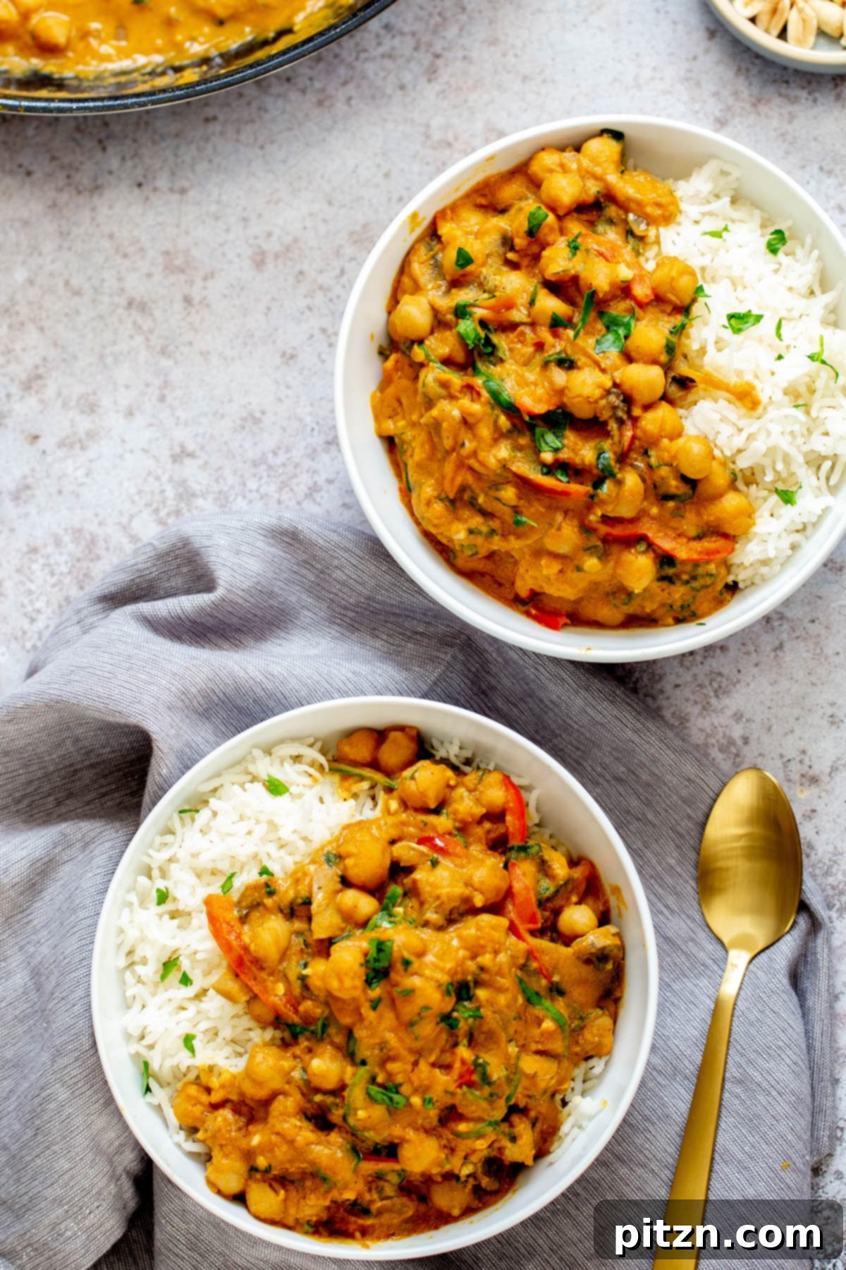 Delicious Vegan Pumpkin Chickpea Curry Two servings of vibrant vegan one-pot chickpea pumpkin curry, garnished and ready to enjoy.