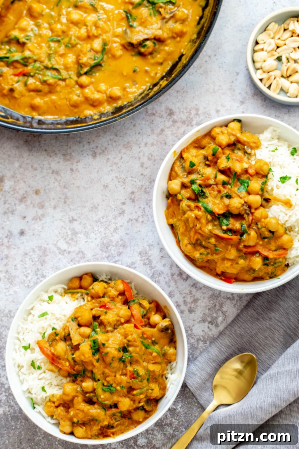 Pumpkin Chickpea Curry Served with Rice Two generous servings of vegan one-pot chickpea pumpkin curry, beautifully presented with a side of rice, ready to be enjoyed as a hearty meal.