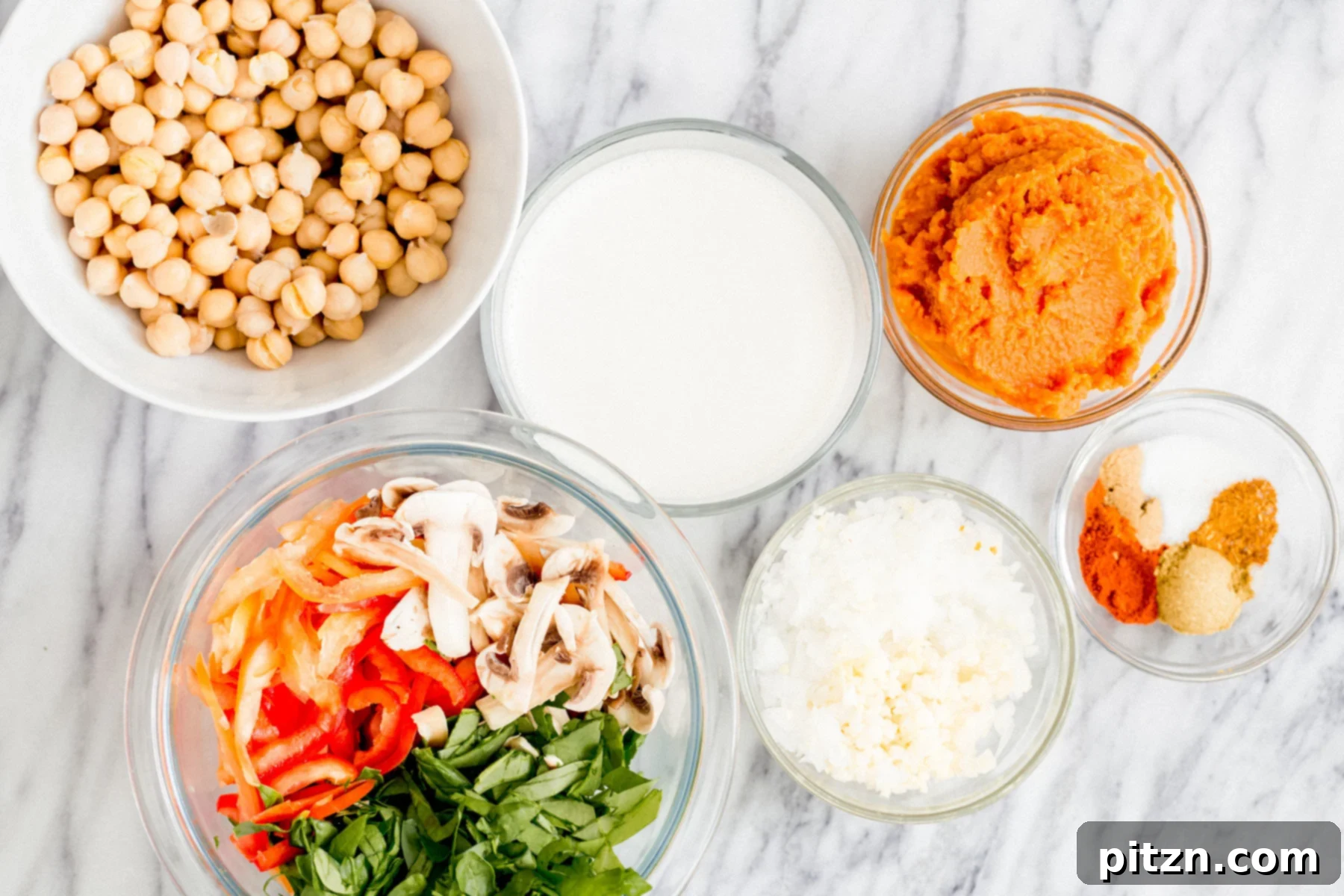 Pumpkin Chickpea Curry Ingredients A colorful array of ingredients laid out, including canned pumpkin puree, chickpeas, spices, and fresh vegetables, ready for making vegan chickpea pumpkin curry.