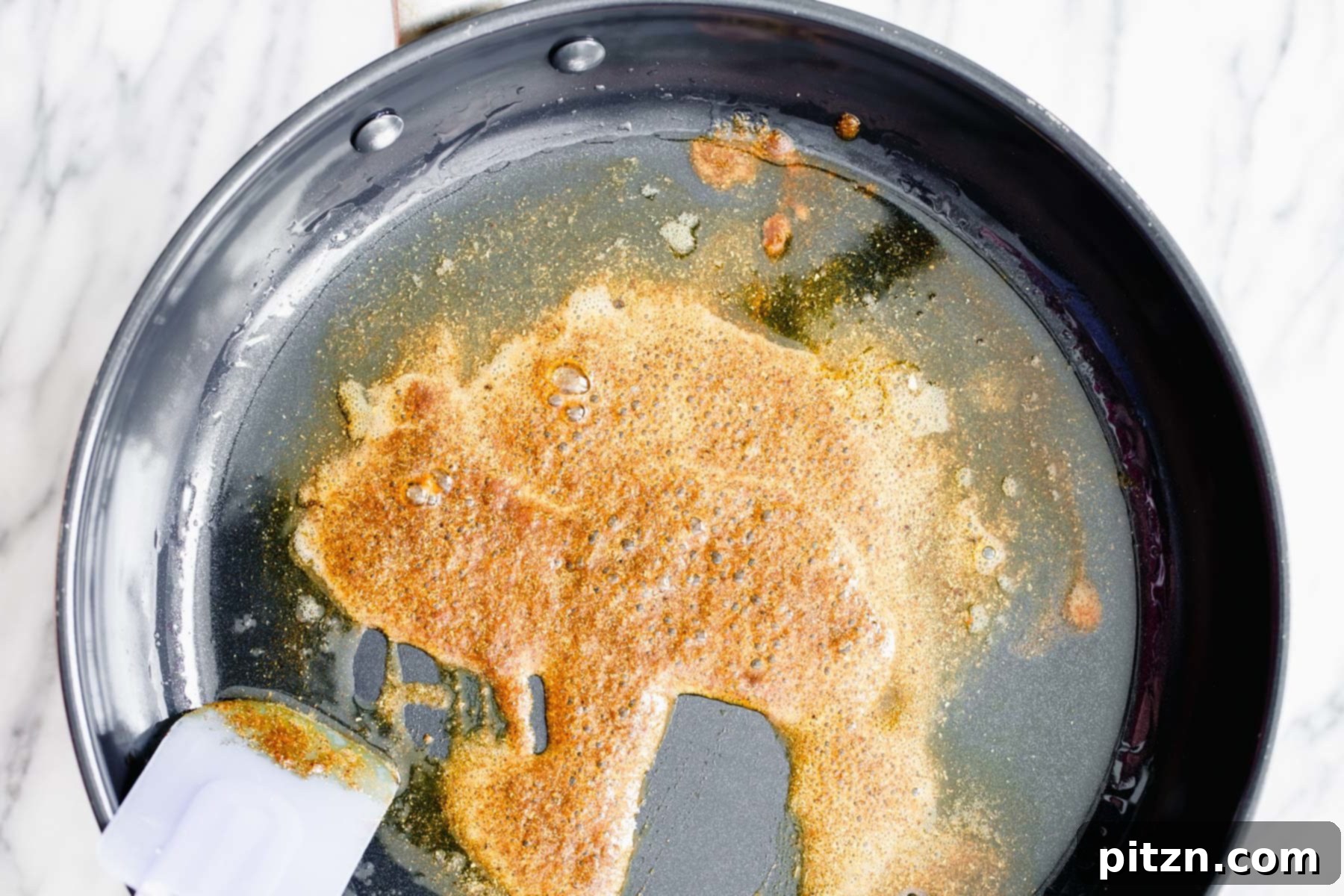 Frying Indian Spices Close-up shot of warming Indian spices sizzling and frying in oil in a skillet, releasing their aromatic compounds.