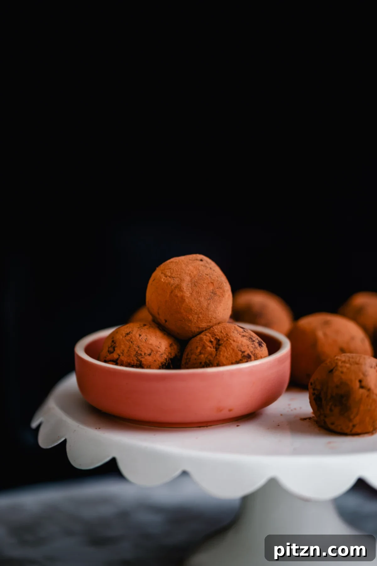 tiramisu truffles vegan homemade tiramisu truffles in a small pink bowl placed on a cake stand