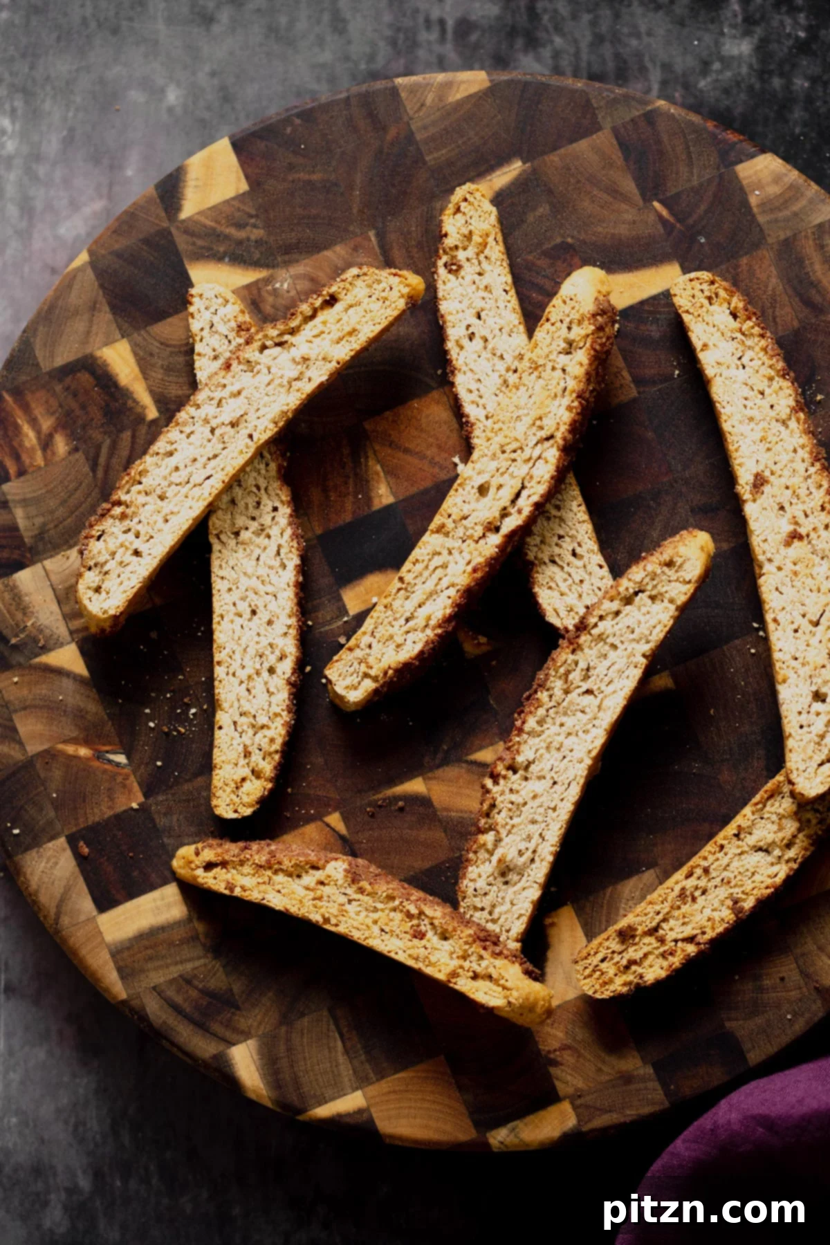 An overhead shot showcasing a beautiful arrangement of vegan cinnamon sugar biscotti on a rustic wooden plate, ready to be enjoyed.